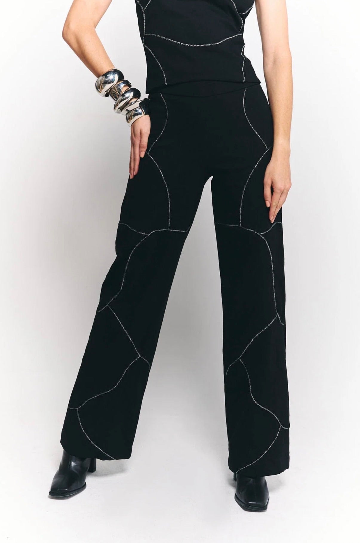 Pantalón Escala de pierna recta con detalles curvos en contraste.